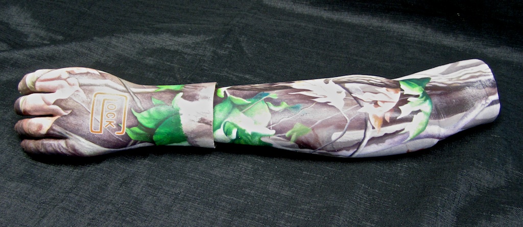 photo: Prosthetic arm covering tattoo painting by Hudson Valley NY artist Katrie Arena.  hunting camo with glock logo.  Painted in 2012. Arm covering with hunting camo tattoo